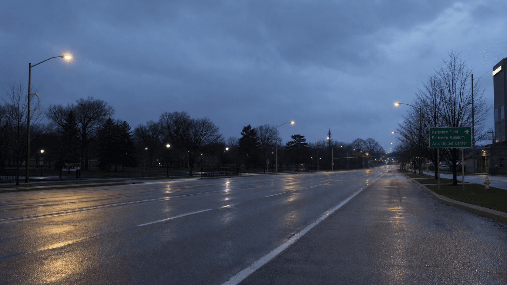 Pre-dawn view of a multi-lane Fort Wayne arterial near a city park, illustrating low-light pedestrian crash conditions on Maysville Road in Allen County, Indiana