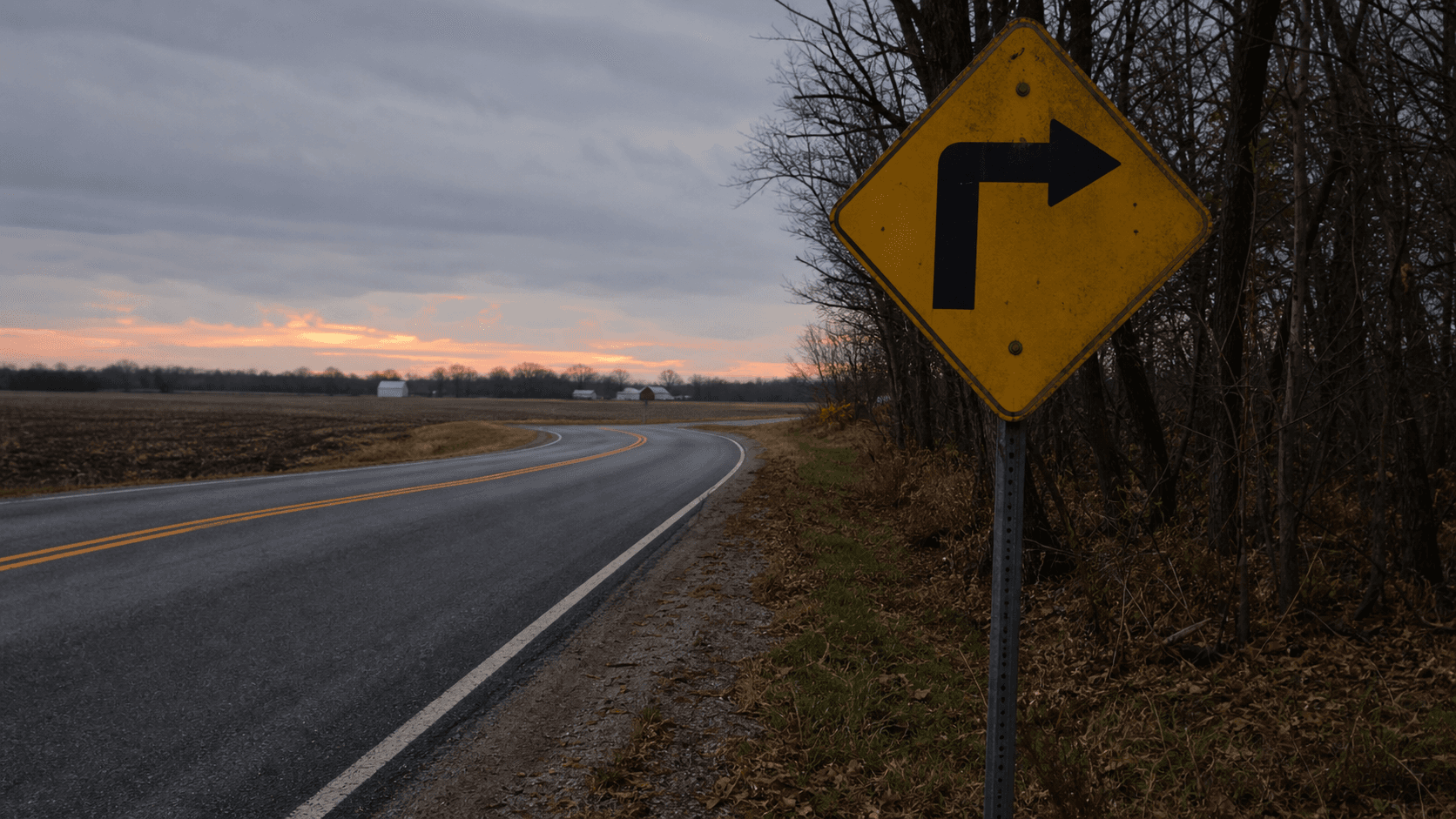A 90-degree curve warning sign on a rural Steuben County, Indiana road near Jackson Township, the type of curve involved in a July 2026 speed-related crash on County Road 450 West