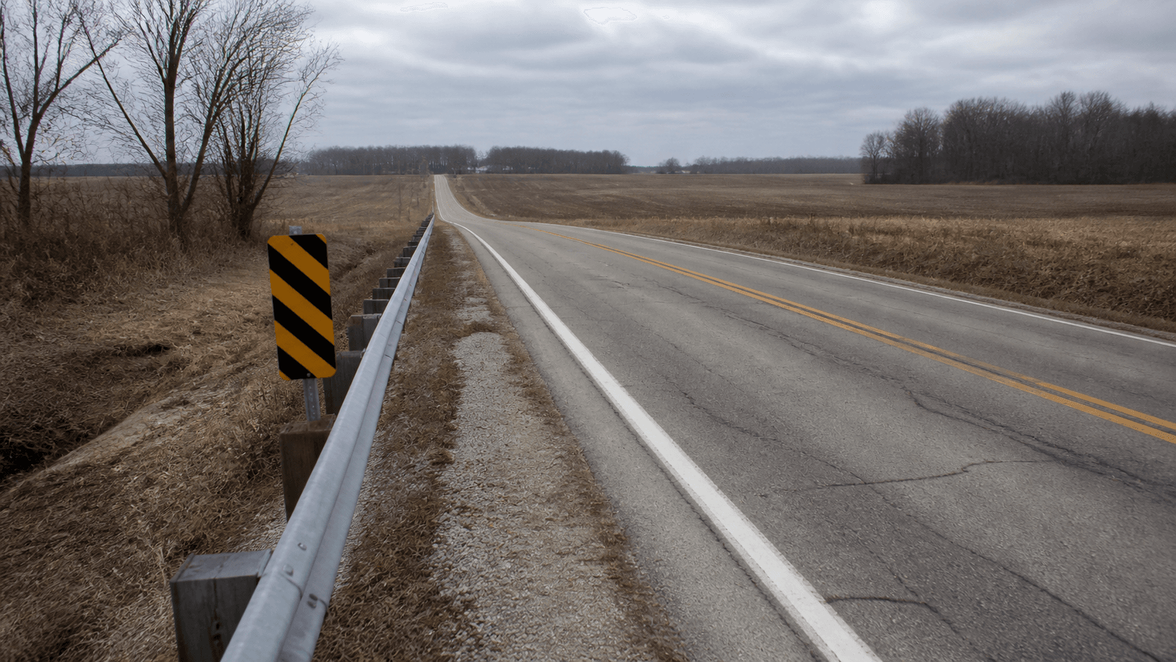 Rural Tyler Road setting with a roadside guardrail in northern Tippecanoe County, representing the location of the reported motorcycle hit-and-run.