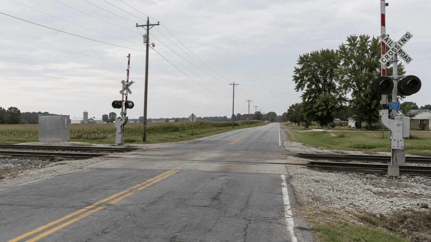 Intersección de una carretera del condado con vías del ferrocarril y postes de servicios públicos en Warsaw, en el condado de Kosciusko, que ilustra el lugar del choque por exceso de velocidad informado.
