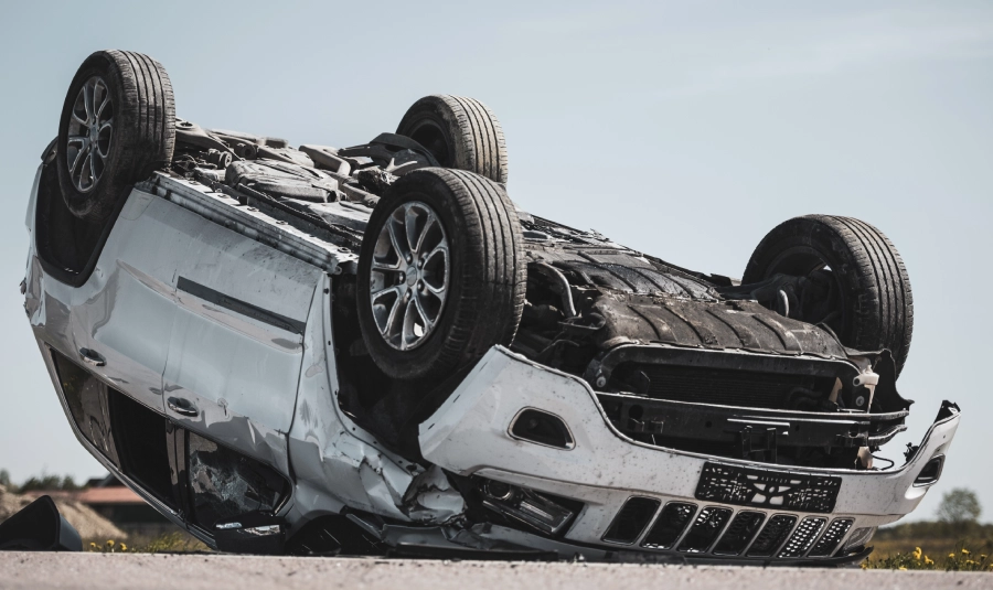A car lays upside down badly damaged after a rollover accident.