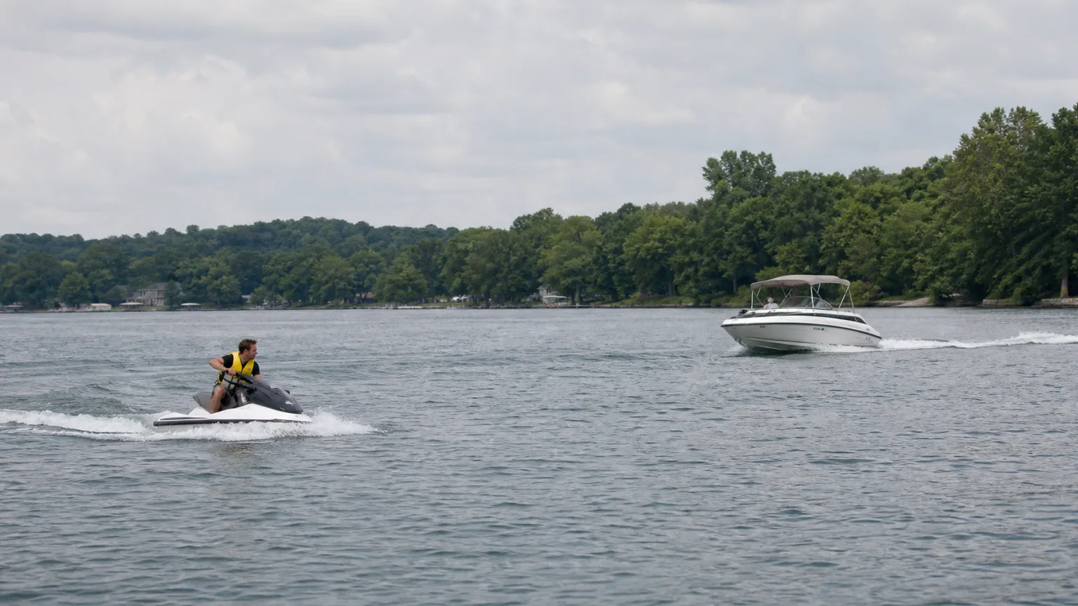 Jet ski and boat operating on a northeast Indiana lake with safe spacing.