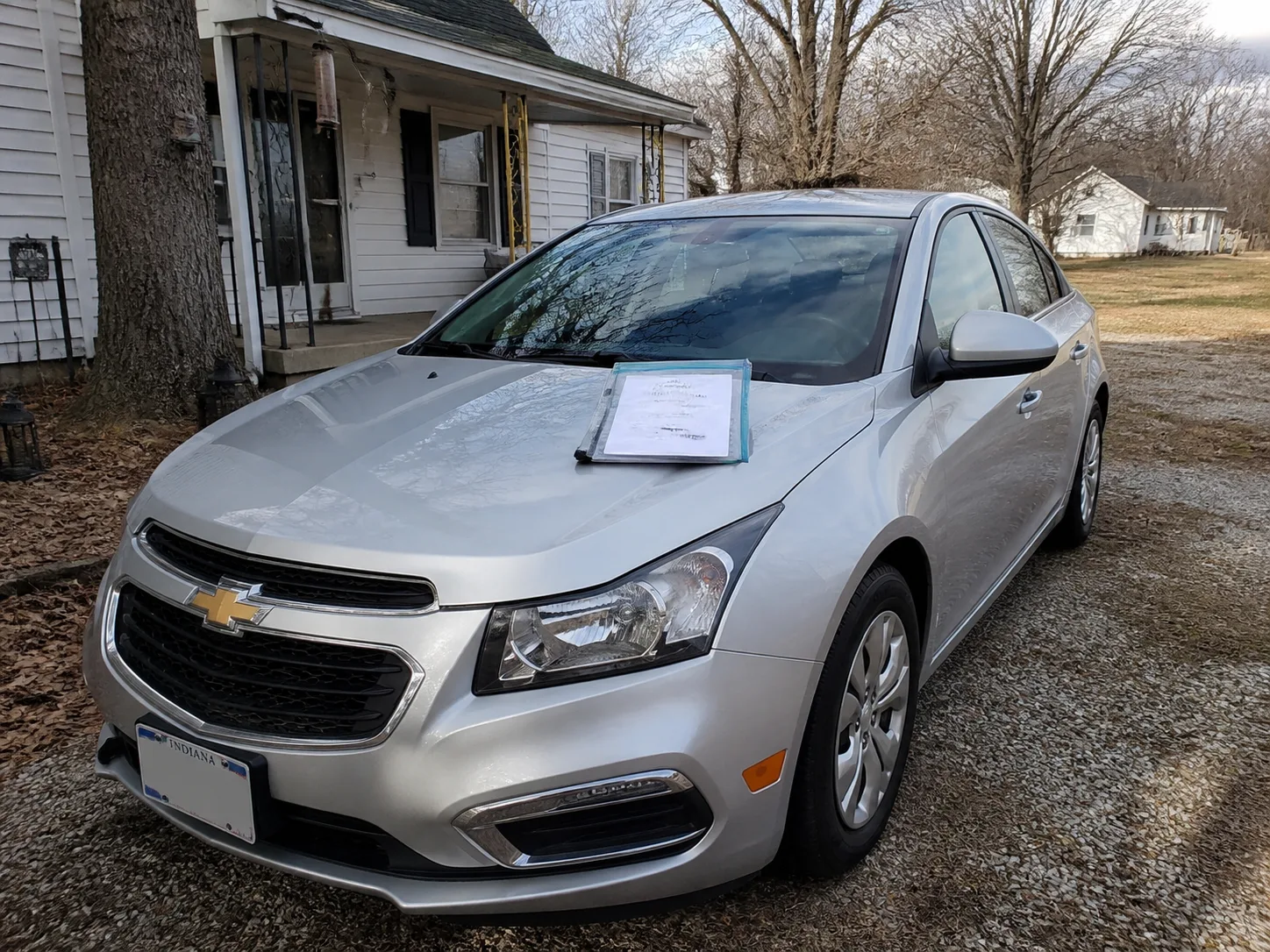 Insured vehicle and policy documents outside an Indiana home