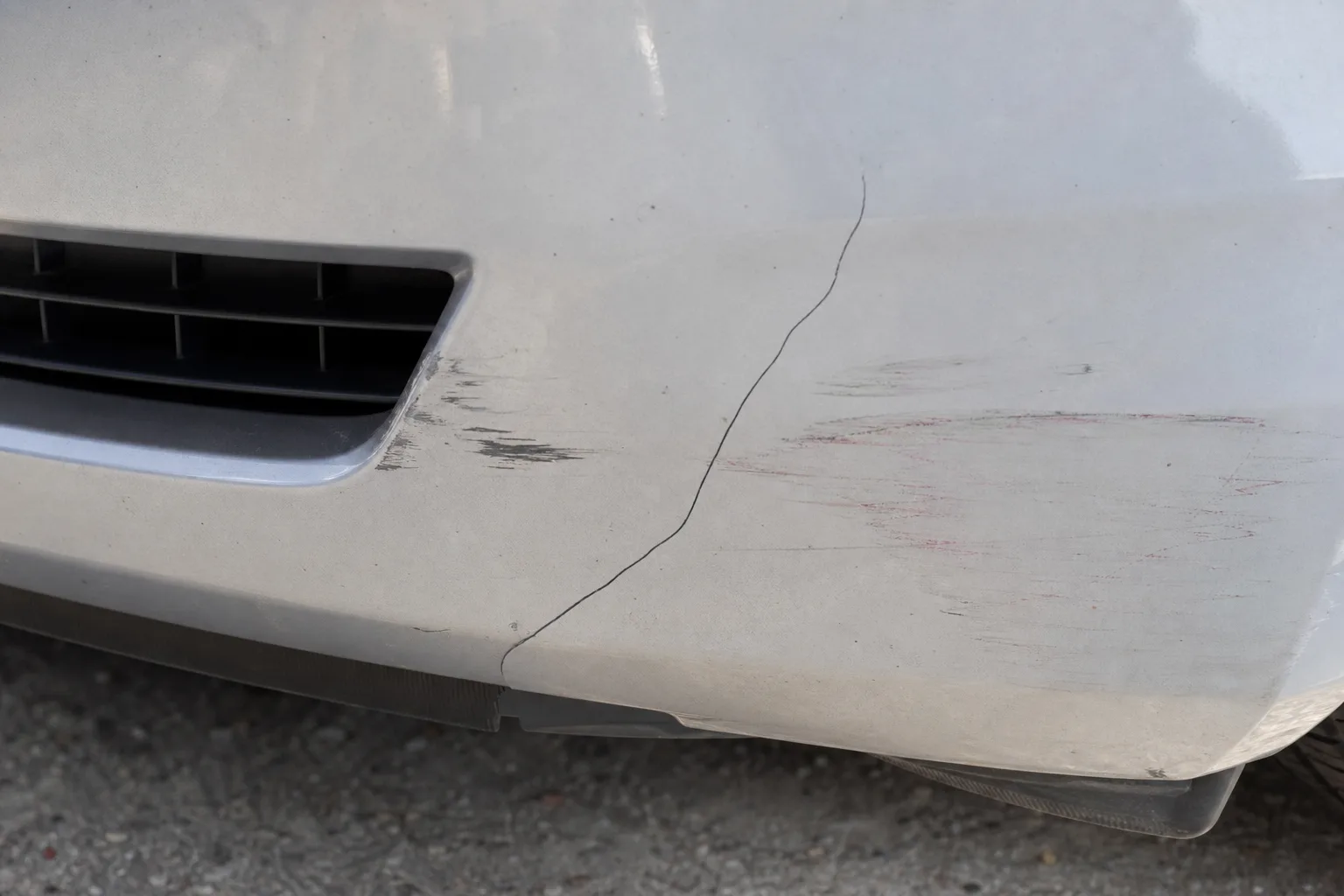 Close-up of minor low-speed collision damage on a car bumper