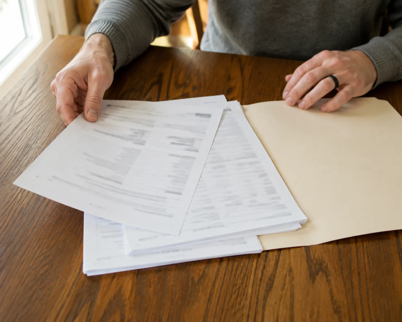 Worker organizing a PPI report and treatment records on a table