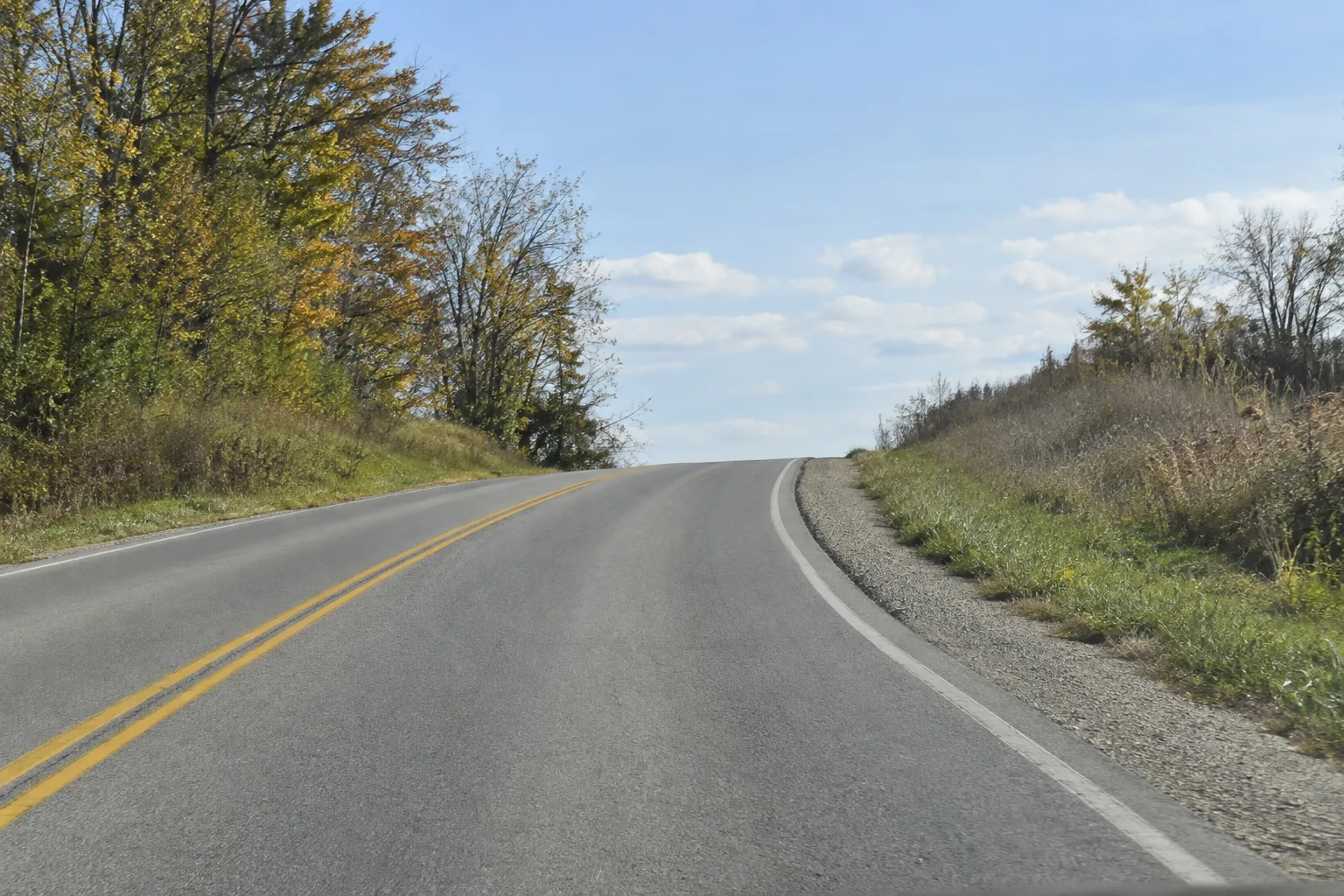 Illustration of a road curving toward a hillcrest with limited visibility
