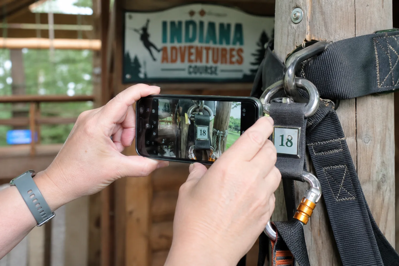 Visitor photographing a safety-harness connection point without touching it