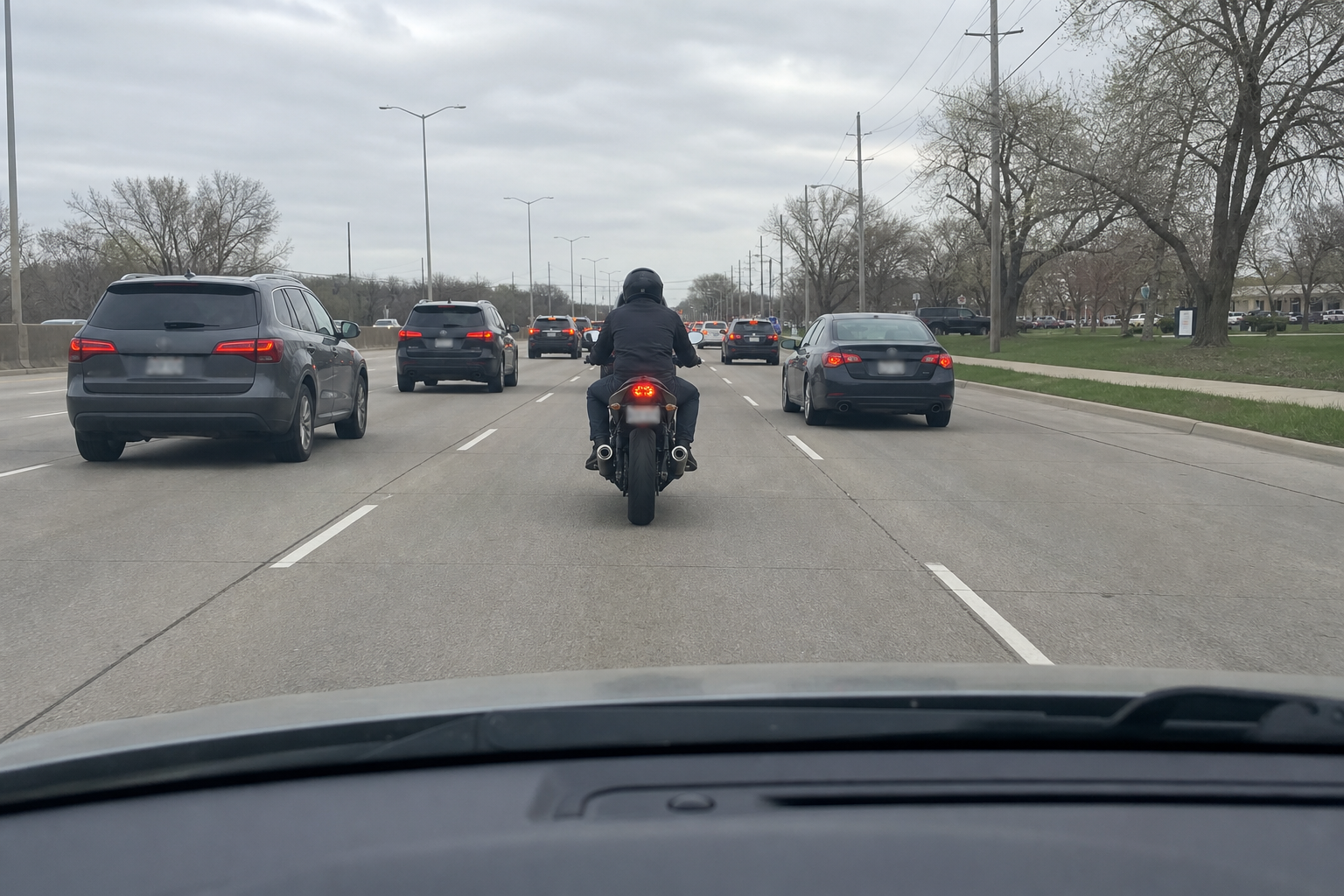 Dashboard camera view of motorcycle centered in its lane in slow Indiana traffic