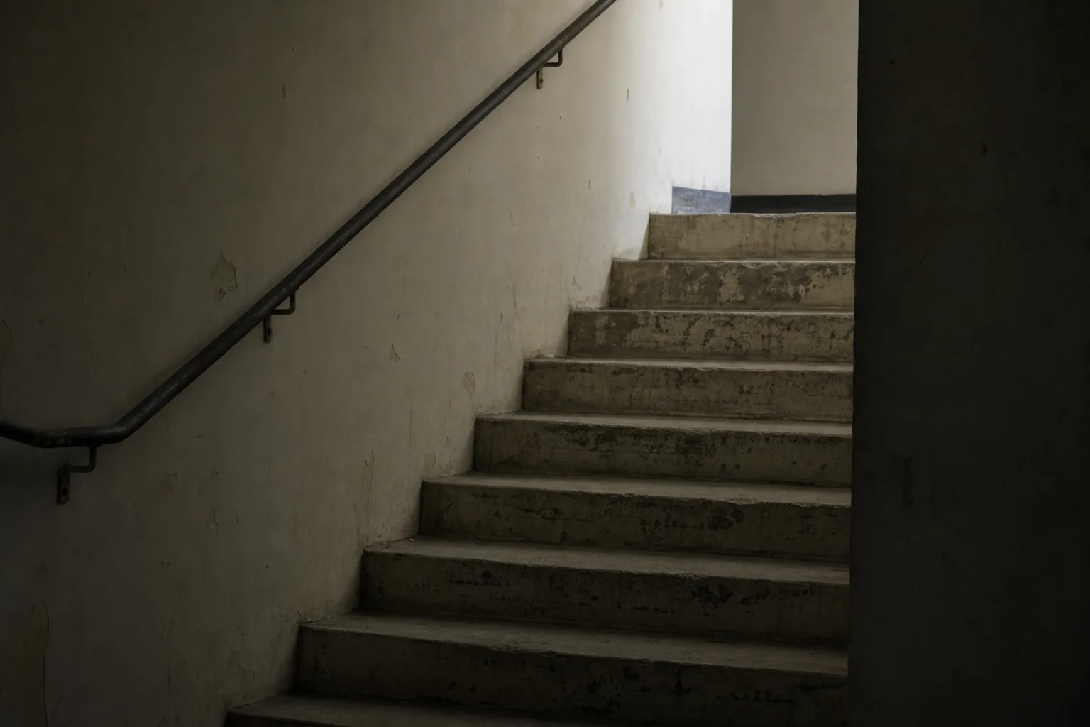 Dim interior stairwell where a worn step edge is hard to see