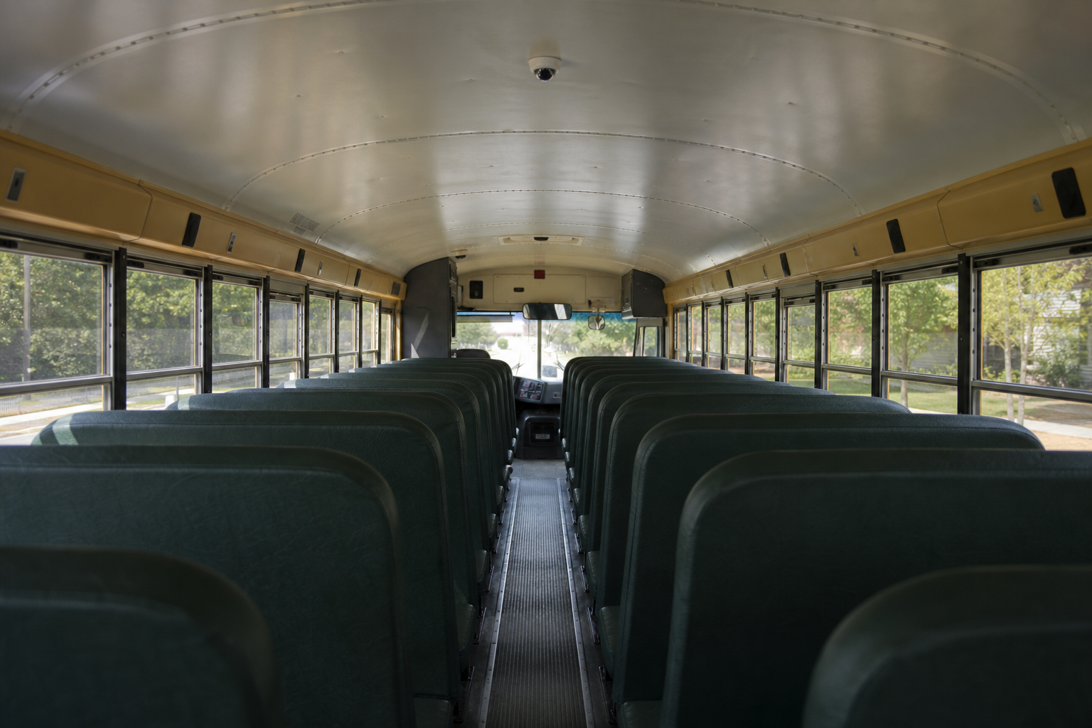 Interior of a school bus showing a mounted camera above the aisle