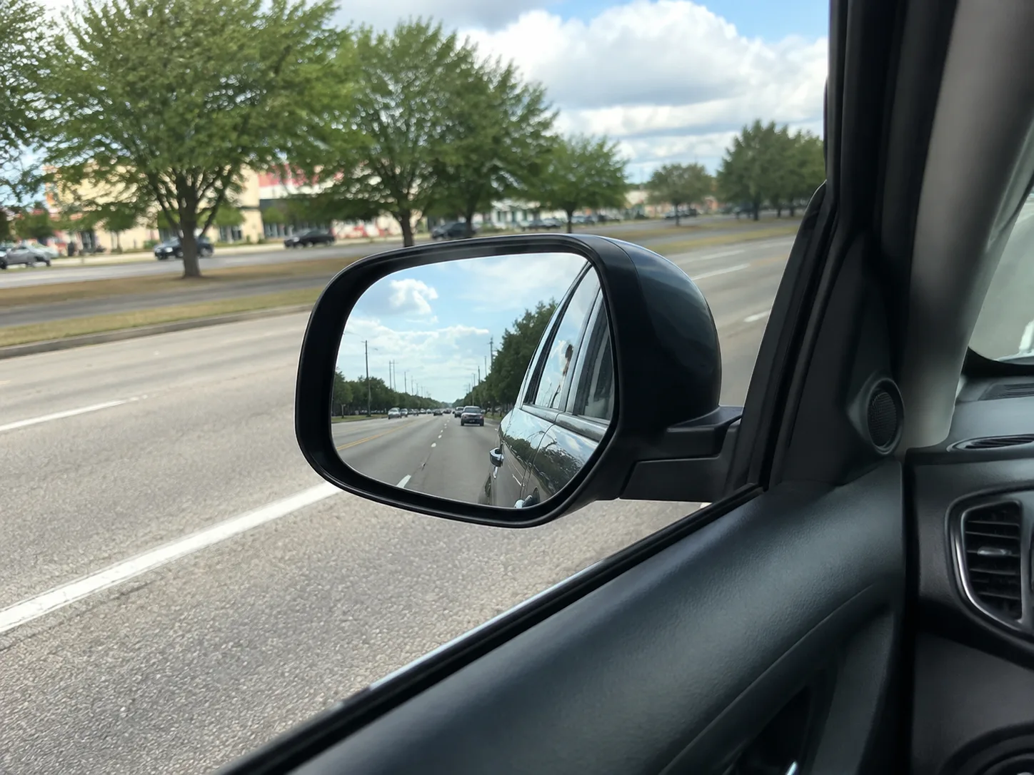 Driver’s side mirror beside an adjacent traffic lane in Fort Wayne