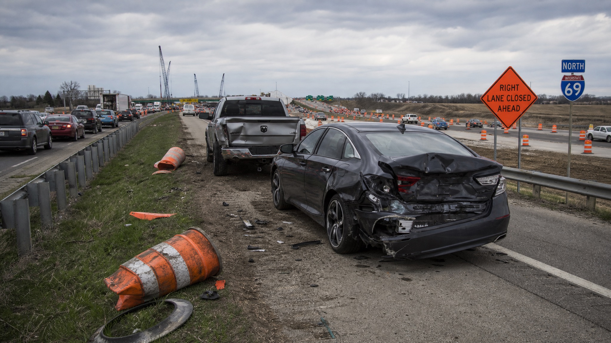 Fort Wayne I-69 construction zone crash aftermath with damaged vehicles and orange barrels