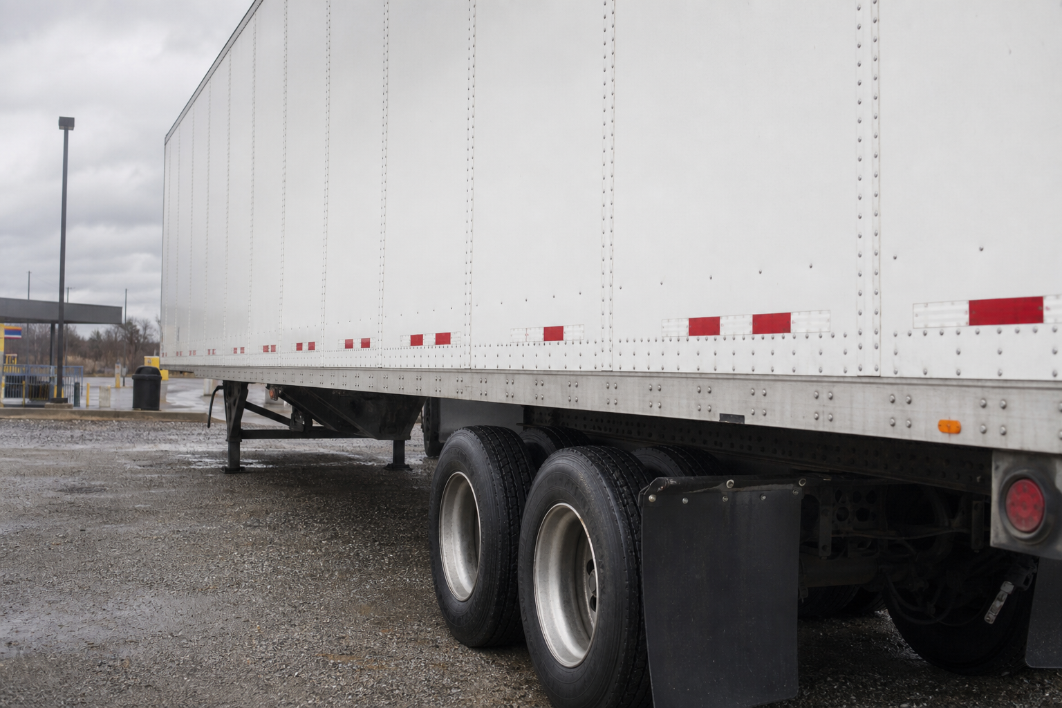Side view of a commercial semi-trailer at a rural Indiana truck stop, illustrating the federal motor-carrier safety issues raised by serious interstate crashes.