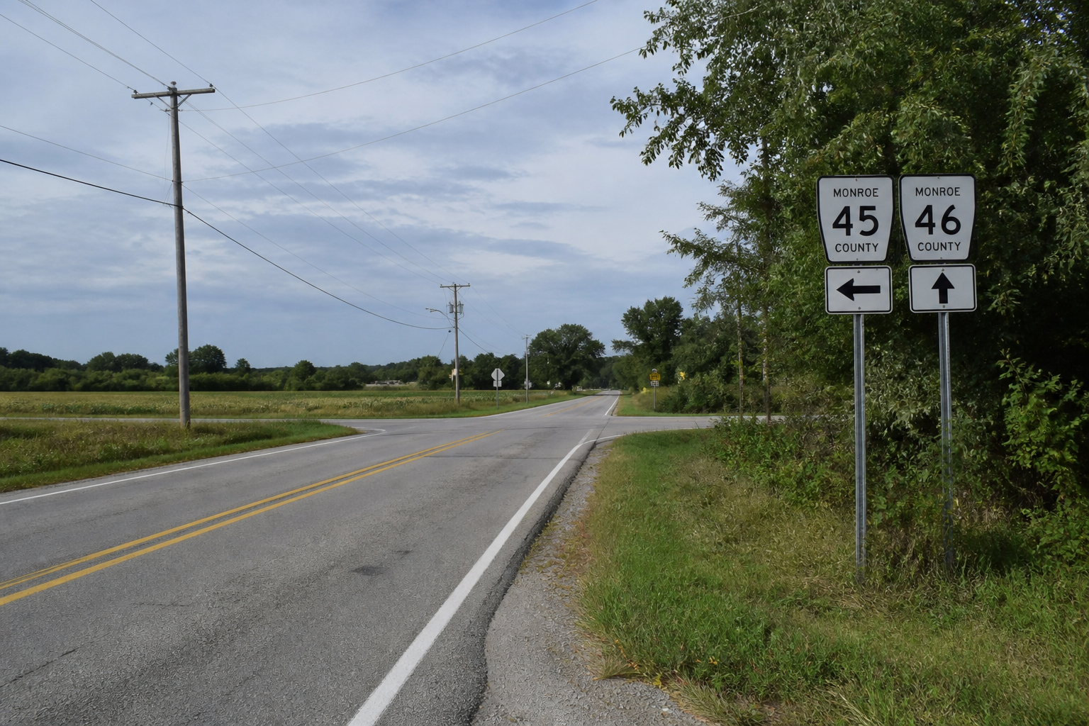 Rural road approach in Monroe County illustrating the sight-line and traffic-control questions investigated after the fatal motorcycle collision.