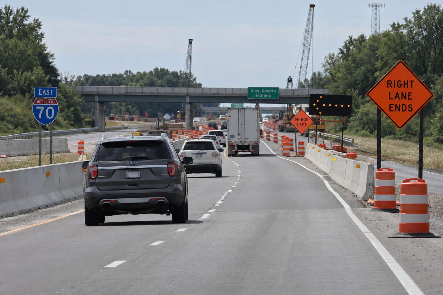 Lane-reduction signs along an Interstate 70 work zone in Clay County provide context for the reported rear-end semi crash.