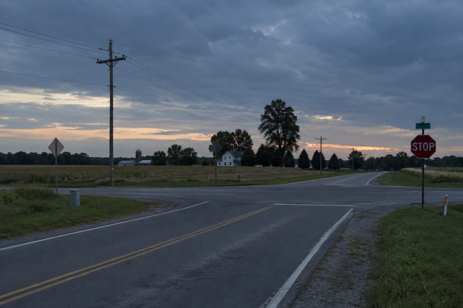A county-road intersection in Elkhart County near dusk, providing context for the County Road 20 dirt bike collision.