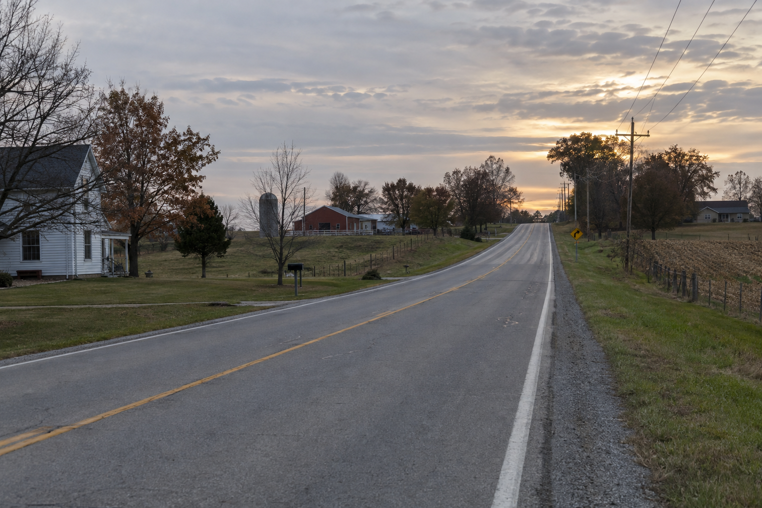Rural two-lane roadway near Wilbur in Morgan County, illustrating visibility concerns for drivers approaching slow-moving equipment.