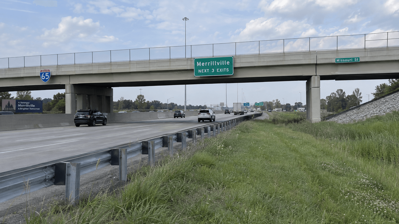 Interstate shoulder, guardrail and overpass in Merrillville, Indiana, providing context for the I-65 semi and sedan crash.
