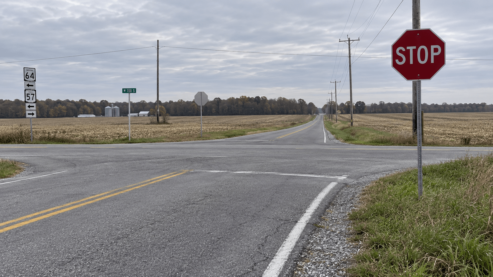 Stop-sign intersection on a rural highway in Gibson County, where traffic enters or crosses Ind. 64.