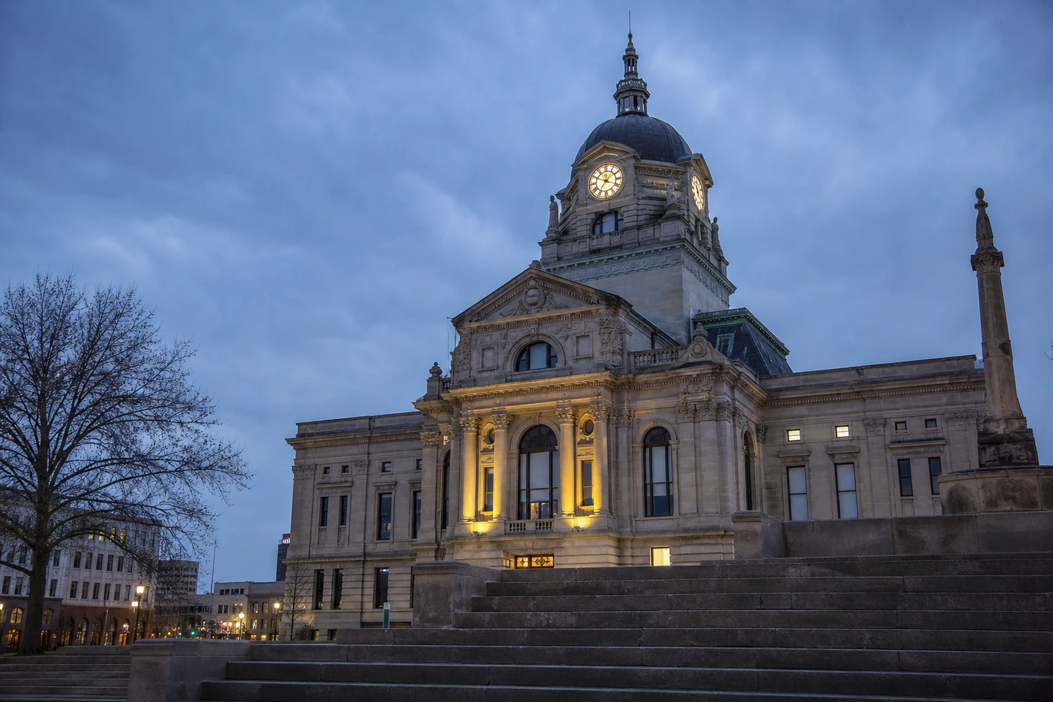 Allen County Courthouse in Fort Wayne at evening blue-hour with the lit clock face glowing and columns illuminated — where Indiana wrongful death lawsuits are filed and tried