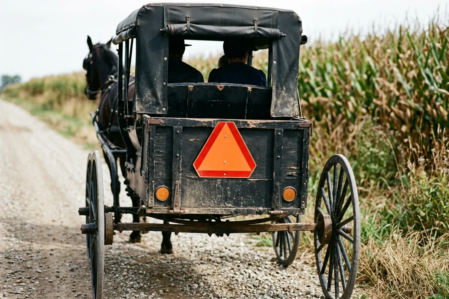 Emblema triangular naranja y rojo de vehículo de baja velocidad en la parte trasera de un carruaje Amish, como exige el Código de Indiana 9-21-9-2