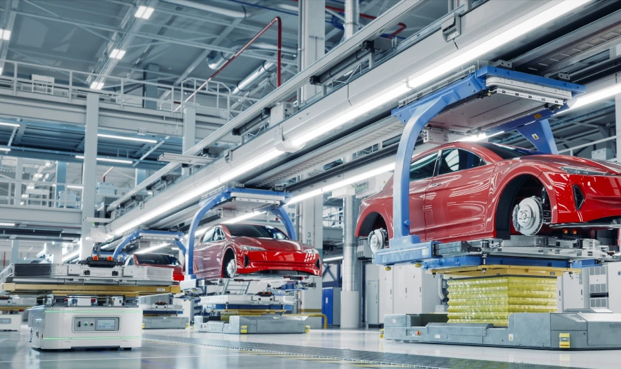 A line of vehicles get assembled in a car factory.