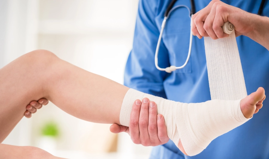 A medical professional wraps a persons ankle.