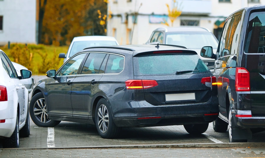 A car sits next to others in a parking lot after side-swiping a car parked next to it.