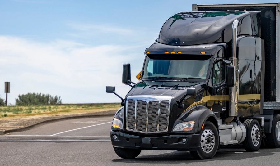 A front view of a parked black semi truck.